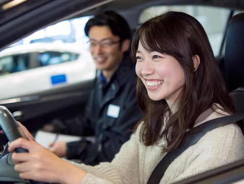 教習車で笑顔の日本人女性が運転を学ぶ自動車教習所