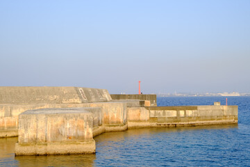 青空と防波堤のある港の風景