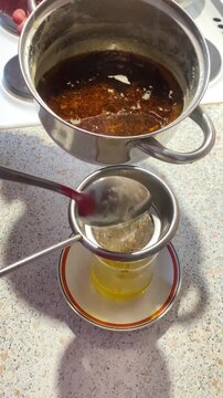 Straining melted ghee through a sieve