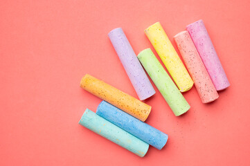 Colored chalks for drawing on pink background flat lay top view. School chalks, back to school, concept of development and education of children, toddlers, art, child activities