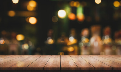 Empty wooden table top with lights bokeh on blur restaurant background.	