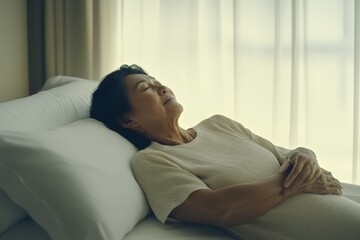 A woman is laying on a bed with her hands on her stomach. She is smiling and she is relaxed