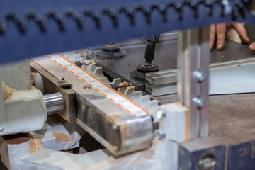 Drilling holes in a board with an industrial drill in a production furniture workshop