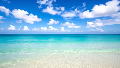 Tranquil beach scene with turquoise water and fluffy clouds.  Vast expanse of ocean meeting the sandy shore
