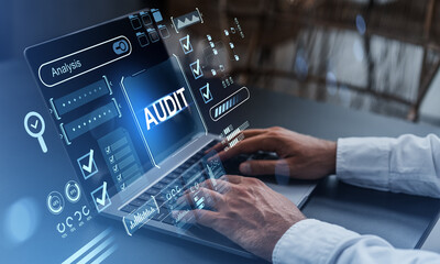 Business audit analysis interface on laptop with digital data overlays on desk..