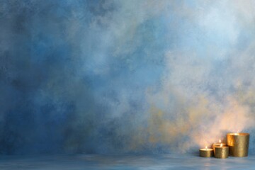 Tranquil candle display against an abstract background: A collection of candles casts a warm and inviting glow against an abstract backdrop of textured blues and golds.