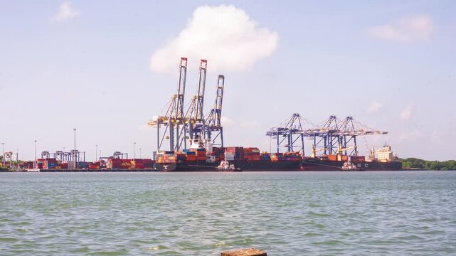 4K timelapse footage of cargo vessels and shipping container operations at Fort Kochi, Kerala, India. The scene captures bustling maritime trade with ships navigating the harbor, containers