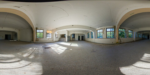 Panoramic view of an abandoned industrial building interior with large windows, peeling walls, and...