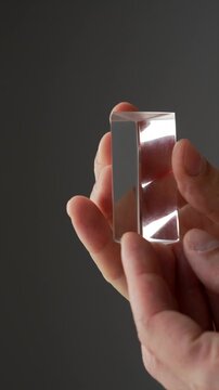 Rectangular crystallized prism for light bending.
Close-up of quadrangular prism.
Glass prism in hands macro video