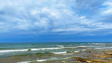 The Caspian Sea. The rocky shore of the Aktau city embankment in Kazakhstan. The ocean is calm and the sky is overcast