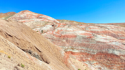 Amazing Martian landscapes in Azerbaijan. The Khizi Mountains are Candy Mountains. An unusual rocky red-and-white slope against a blue sky background