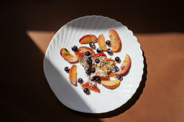 Fruit yogurt bowl with peaches, blueberries and granola