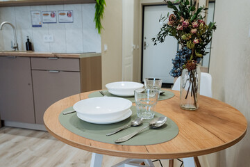 Experience a stunning dining setup in a modern kitchen, featuring a beautiful floral centerpiece and elegant glassware, enhancing the spaces aesthetic and creating a warm, inviting atmosphere