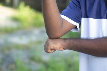Close up of a persons elbow and forearm with a fist