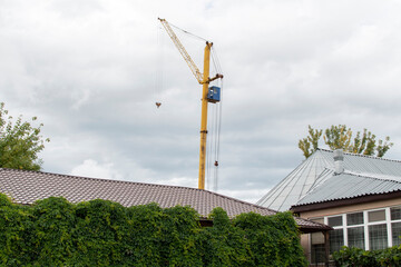 Obraz premium Crane and roof of a building against rainy sky 
