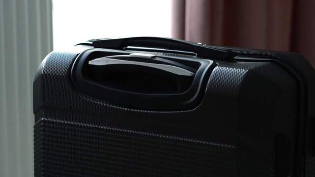Handle on a travel suitcase.
Nylon and compact shockproof suitcase for travel.
Roomy travel suitcase for transporting personal belongings and clothes.