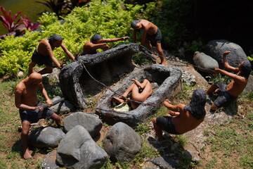 Diorama of a statue of human activity in the ancient Stone Age closing a stone coffin
