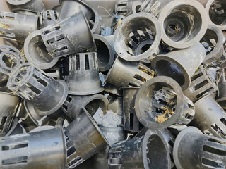 A pile of dirty net pots waiting to be washed after harvest. Net pots are used as containers for hydroponic plants.