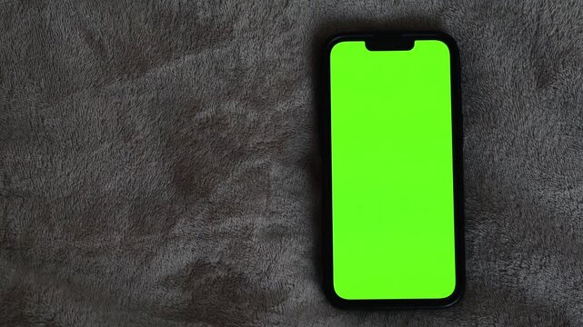 Green display on mobile phone.
Change background on mobile phone.
Close-up of empty green screen.
Modern technologies and business
