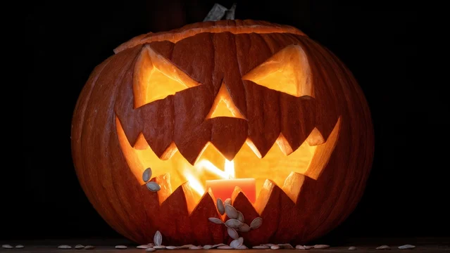 Eerie Jack O Lantern Glow with Flame Illuminating Inner Seeds