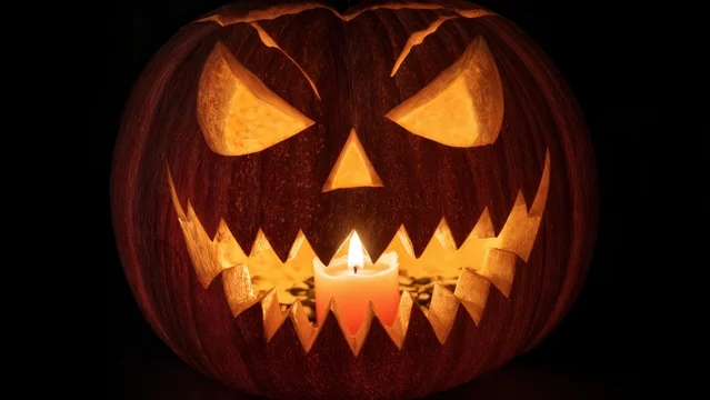 Warm Candlelight Shining Through Carved Jack O Lantern Design
