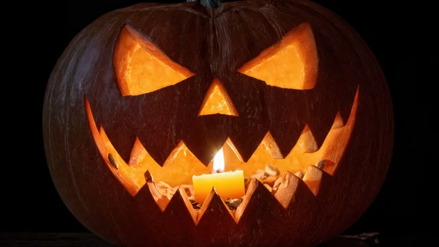 Glowing Halloween Pumpkin with Sinister Expression in Darkness