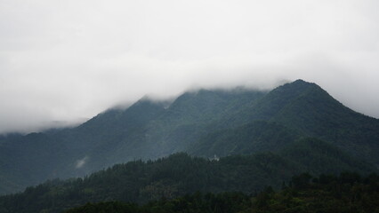 The beautiful mountains view with the covered fog on them