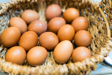 Fresh brown eggs inside a wicker basket
