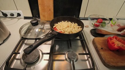 Pouring pasta into pan with tomato sauce cooking in authentic home kitchen atmosphere - Powered by Adobe