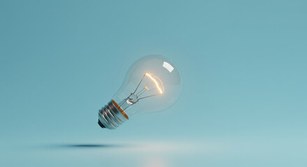 Glowing incandescent lightbulb levitates against a pale blue backdrop.