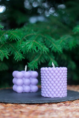 Lilac handmade beeswax candles in bubble cube and textured pillar shapes. Eco-friendly natural wax candles for decoration, relaxation, and interior design.