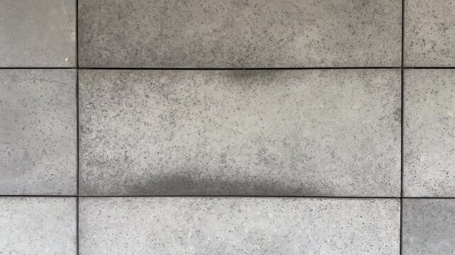 Close-up view of facade tiles crafted from architectural concrete, highlighting their smooth surface, modern texture, and geometric arrangement.
