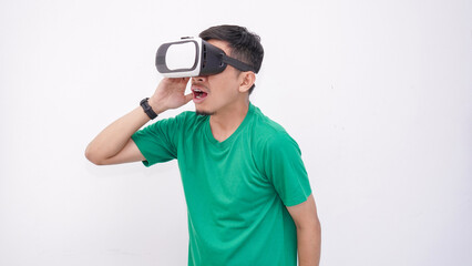 Young Asian man playing with a VR glasses isolate on white background, wearing green t-shirt