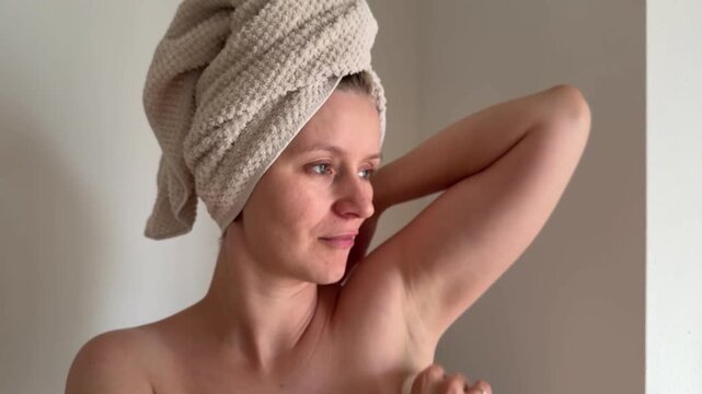 Woman applying antiperspirant deodorant to underarm area, close-up body care and hygiene routine, personal grooming and self-care concept at home