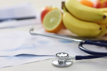 Health-focused imagery featuring stethoscope and fresh fruits on a table.