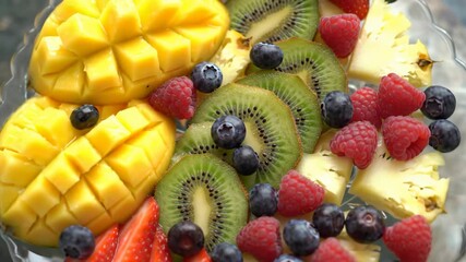 Colorful assortment of fresh fruits on a plate, healthy eating idea.