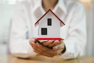 A real estate agent hands over keys after signing a property contract, symbolizing investment, ownership, mortgage, financial success, and homeownership achievement.