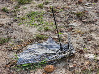 Discarded Leopard Print Umbrella on Dry Ground