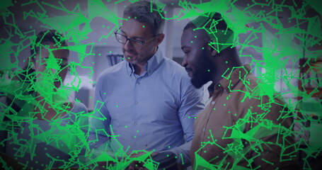 Group of professionals collaborating around laptop in office workspace, with network overlay