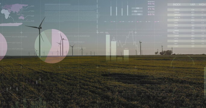 Rotating wind turbine producing power on grassy plain at dusk, with digital data graphs