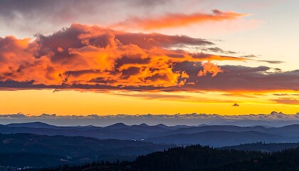 Obraz premium Vibrant sunset over rolling hills with dramatic clouds