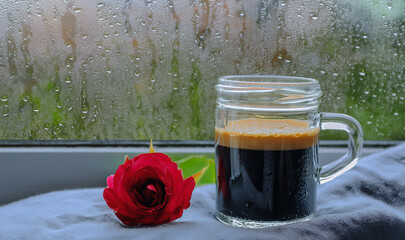 A glass of Espresso coffee with red rose and rain drops on window in raining day. Concept for drinking beverage at home and staying at home on holidays. Generated image