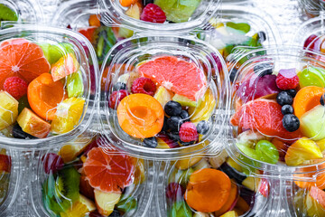 Boxes with pre-packaged fruit salads in a commercial fridge