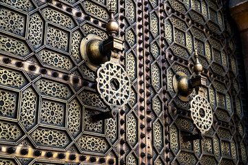 Close-up of a traditional Moroccan door at Hassan Tower in Rabat, Morocco. The ornate brass...