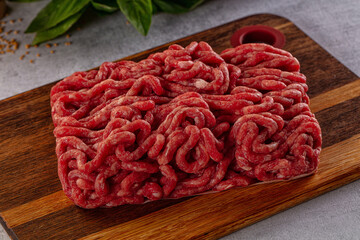 Raw minced beef meat over board