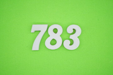 The numbers are made of white painted wood and placed on a green paper background.