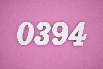 The numbers are made of white painted wood, placed on a pink paper background.