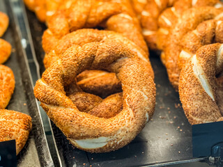 Fresh Turkish simit with sesame seeds in bakery display. Nutrition, culture and lifestyle in everyday food traditions and retail environments.