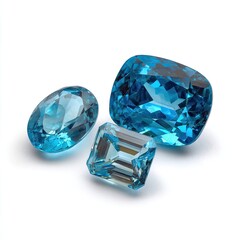 Three vibrant, faceted gemstones, shades of azure blue, displayed against a pure white background