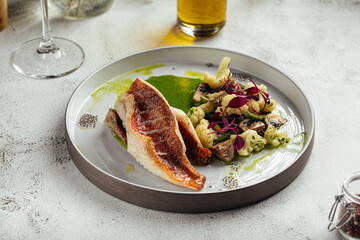 Elegant plate with grilled sea bass, mushrooms, and puree